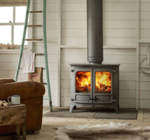 poêle à bois Island 3 sur pieds bas de couleur noir de la marque Charnwood en situation dans le salon d'une maison